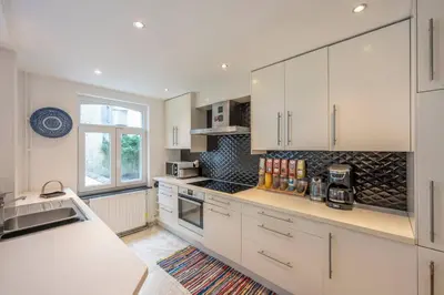 a kitchen with white cabinets and a counter top at Euro Edens Cosy Historic Home in Brussels Jacuzzi, Garden, Central Location in Brussels