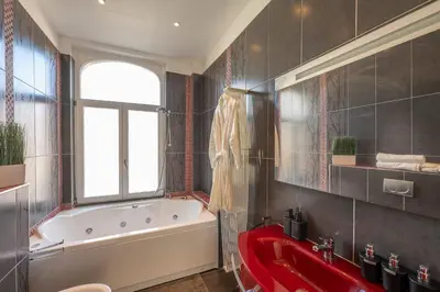 a bathroom with a red tub and a red sink at Euro Edens Cosy Historic Home in Brussels Jacuzzi, Garden, Central Location in Brussels