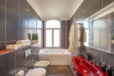 a bathroom with a red sink and a bath tub at Euro Edens Cosy Historic Home in Brussels Jacuzzi, Garden, Central Location in Brussels