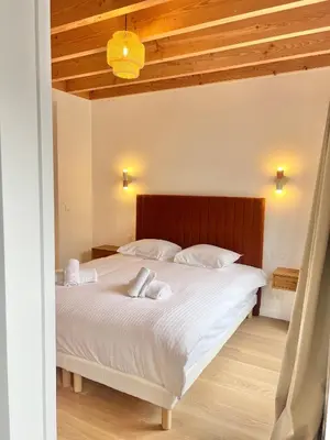 a bedroom with a large white bed with a wooden headboard at Duplex Design & Élégant au Coeur de Bruxelles in Brussels