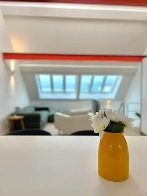 an orange vase with white flowers on a table at Duplex Design & Élégant au Coeur de Bruxelles in Brussels