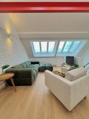 a large living room with couches and a tv at Duplex Design & Élégant au Coeur de Bruxelles in Brussels