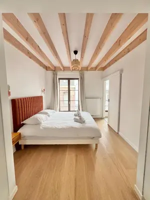 a bedroom with a bed and a wooden ceiling at Duplex Design & Élégant au Coeur de Bruxelles in Brussels