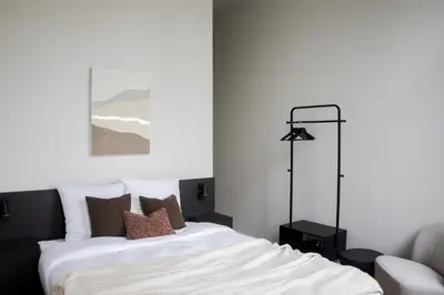 a bedroom with a bed with white sheets and pillows at ROMY ANTWERP Sint-Jansvliet in Antwerp