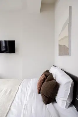 a bed with white sheets and a brown towel on it at ROMY ANTWERP Sint-Jansvliet in Antwerp