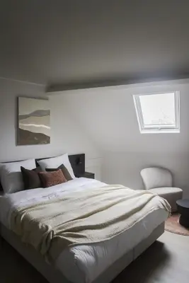 a white bedroom with a large bed and a window at ROMY ANTWERP Sint-Jansvliet in Antwerp