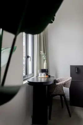 a table and a chair in a room with a window at ROMY ANTWERP Sint-Jansvliet in Antwerp