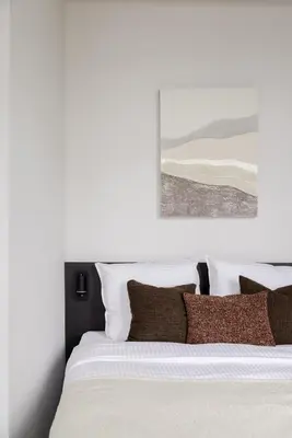 a bedroom with a bed with white sheets and brown pillows at ROMY ANTWERP Sint-Jansvliet in Antwerp