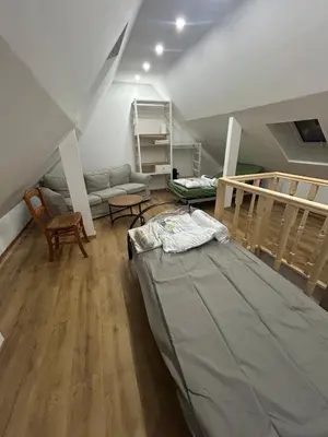 a attic room with a bed and a staircase at Sisel Apart House in Temse
