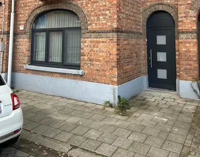 a brick building with a black door and windows at Sisel Apart House in Temse
