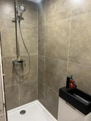 a shower stall in a bathroom with a sink at Sisel Apart House in Temse
