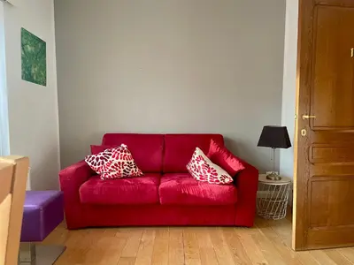 a red couch with pillows on it in a room at River City in Beersel