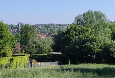 a garden with a fence and trees in the background at River City in Beersel