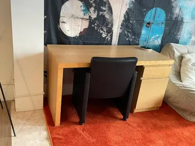a wooden desk with a black chair next to a bed at River City in Beersel