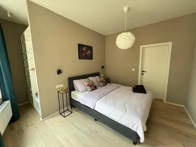 a bedroom with a large bed with white sheets at Modern apartment - Lier in Lier