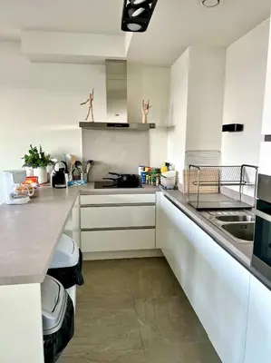 a kitchen with white cabinets and a counter top at Elegant Apartment Near Atomium Ideal for Families in Brussels