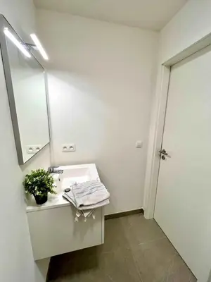 a white bathroom with a sink and a mirror at Elegant Apartment Near Atomium Ideal for Families in Brussels