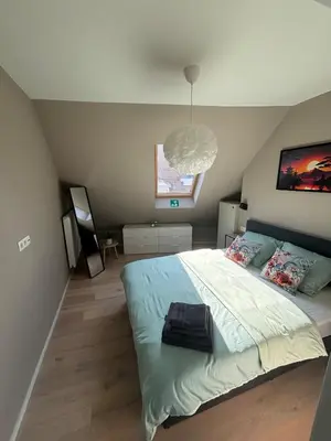 a bedroom with a bed and a pendant light at Minimalist apartment - Lier center in Lier