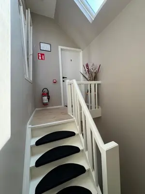a white staircase with black pillows on it at Minimalist apartment - Lier center in Lier