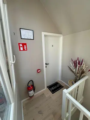 a hallway with a white door and a stair case at Minimalist apartment - Lier center in Lier