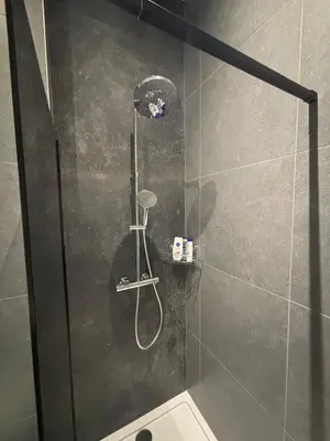 a shower with a shower head in a bathroom at Minimalist apartment - Lier center in Lier