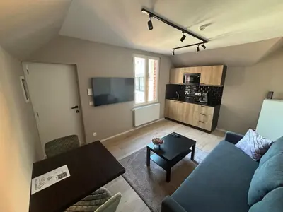 a living room with a blue couch and a table at Minimalist apartment - Lier center in Lier