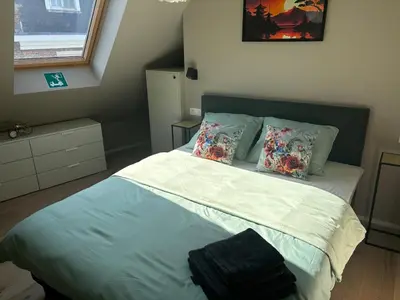 a bedroom with a bed with blue sheets and pillows at Minimalist apartment - Lier center in Lier