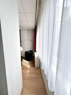 a hallway with white curtains and wooden floors at Stunning Central Studio 2 Min from Grand Place in Brussels
