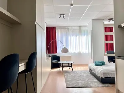 a bedroom with a bed and a table and chairs at Stunning Central Studio 2 Min from Grand Place in Brussels