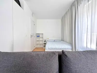 a white bedroom with a bed and a window at Lovely Studio with Balcony by Grand Place for 4 in Brussels