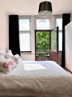 a bedroom with a large white bed and a window at Chic Studio Heart of the City with Balcony in Brussels