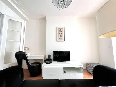 a living room with a couch and a tv at Chic Studio Heart of the City with Balcony in Brussels