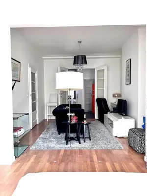 a living room with a black couch and a table at Chic Studio Heart of the City with Balcony in Brussels