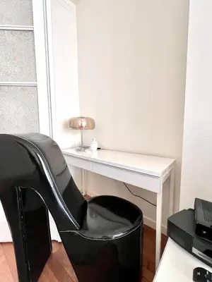 a black chair sitting next to a white desk at Chic Studio Heart of the City with Balcony in Brussels