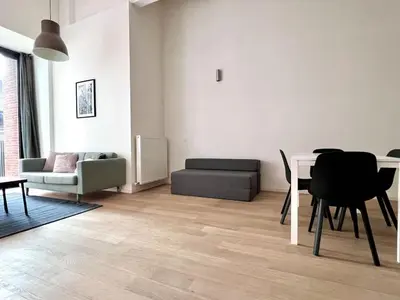 a living room with a table and a couch at Bright Modern Loft in Central Brussels for 4 in Brussels
