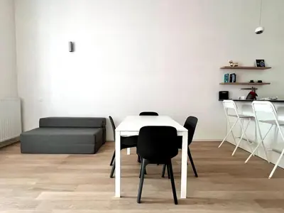 a white table and chairs in a living room at Bright Modern Loft in Central Brussels for 4 in Brussels