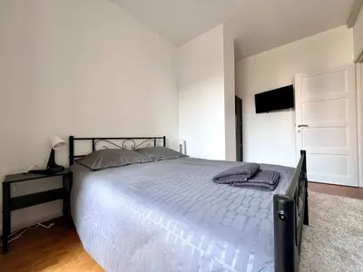 a bedroom with a large bed and a television at Cosy Family Apartment for up to 9 guests near Brussels Midi Station in Brussels