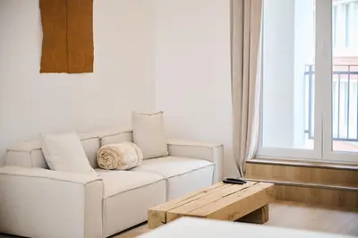 a living room with a white couch and a wooden coffee table at Gallery Louise 2 in Brussels