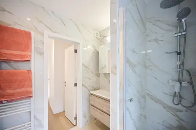 a bathroom with a shower with marble walls at Gallery Louise 2 in Brussels