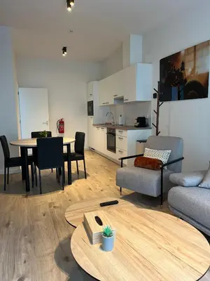 a living room with a table and a couch and a kitchen at FDS Luxe House in Ghent