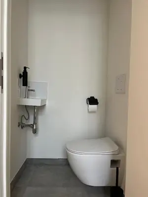 a white bathroom with a toilet and a sink at FDS Luxe House in Ghent