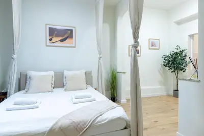 a bedroom with a bed with white sheets and pillows at Studio idéal pour visiter Bruxelles in Brussels