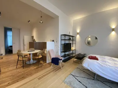 a bedroom with a bed and a table and chairs at New Apartment center of Trendy St Gille in Brussels