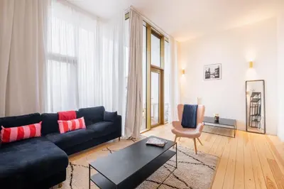 a living room with a blue couch and a chair at New Apartment center of Trendy St Gille in Brussels