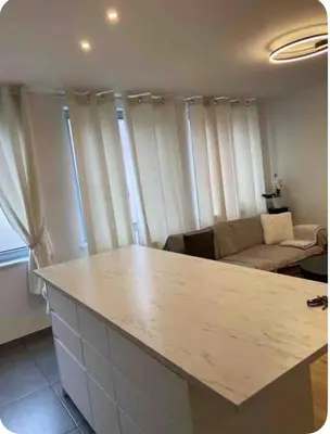 a kitchen with a white counter top in a living room at Apparemment 1 chambre in Brussels