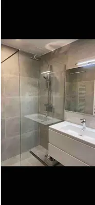 a bathroom with a sink and a glass shower at Apparemment 1 chambre in Brussels