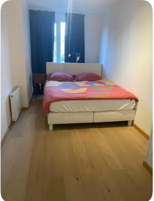 a bedroom with a bed and a wooden floor at Apparemment 1 chambre in Brussels