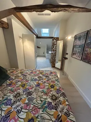 a bedroom with a bed with a floral bedspread at Historic Charm Penthouse Leuven in Leuven
