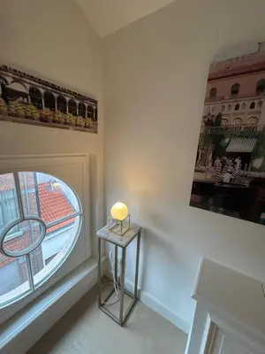 a small table with a light on it next to a window at Historic Charm Penthouse Leuven in Leuven