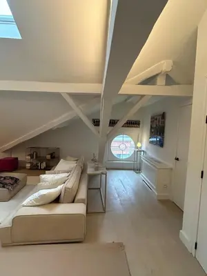 a living room with a couch and a table at Historic Charm Penthouse Leuven in Leuven